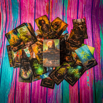 An overhead shot showcasing the "Ethereal Herb Tarot" deck by Puff Pass Printing. The box, prominently placed in the center, features a mystical landscape with a glowing full moon, tall trees, and a serene sky. Surrounding the box are an array of tarot cards from the deck, each illustrating intricate and imaginative cannabis-themed artwork. The vibrant, colorful background enhances the enchanting and magical atmosphere, highlighting the unique blend of tarot and cannabis mysticism in the deck's design.